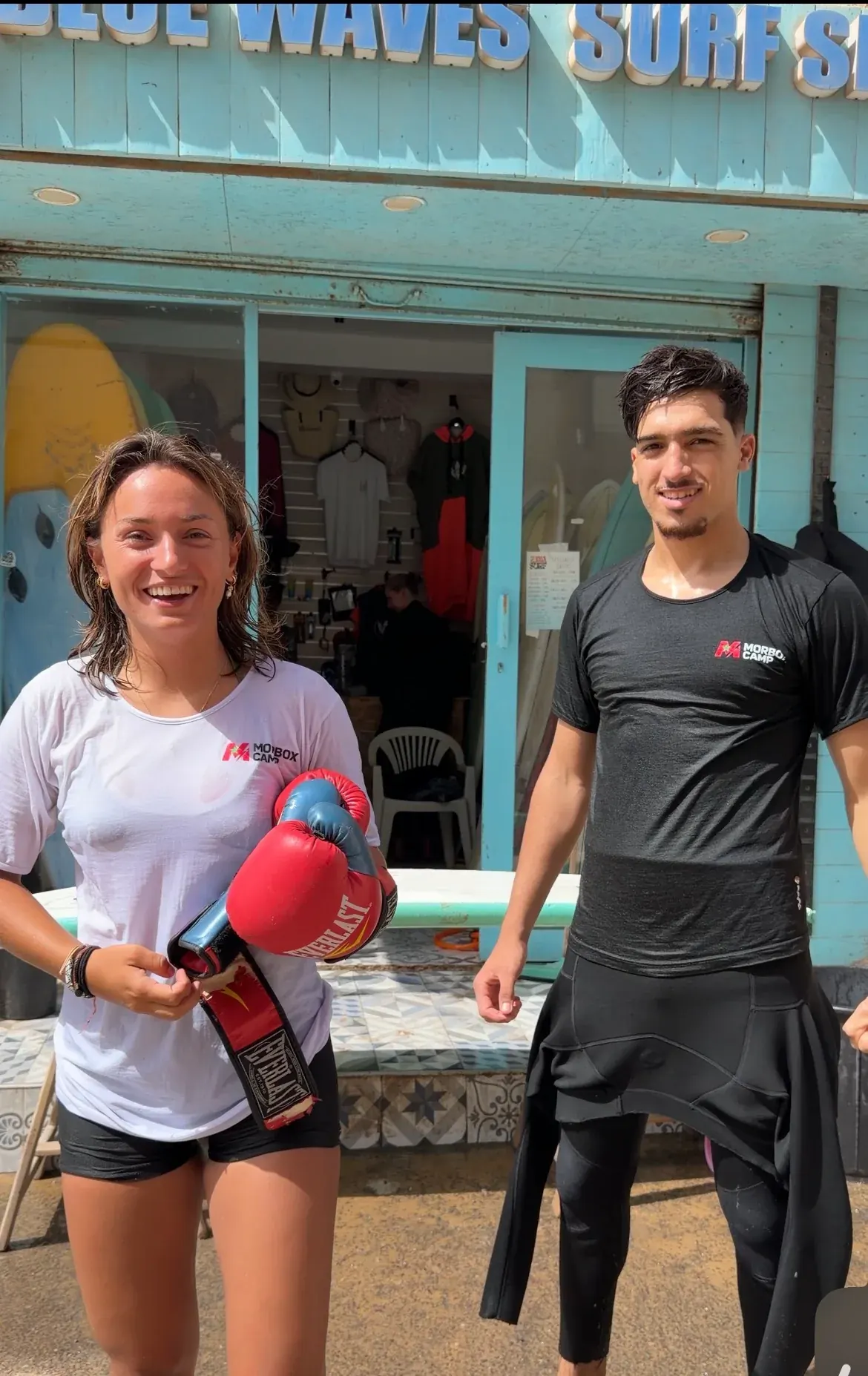 Morbox team members in camp shirts with boxing gloves outside the surf shop