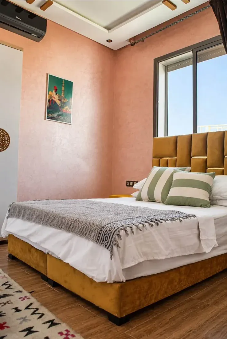 Double bedroom with a mustard bed and peach walls