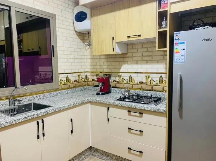 Kitchen with fitted cabinets, refrigerator and cooking area