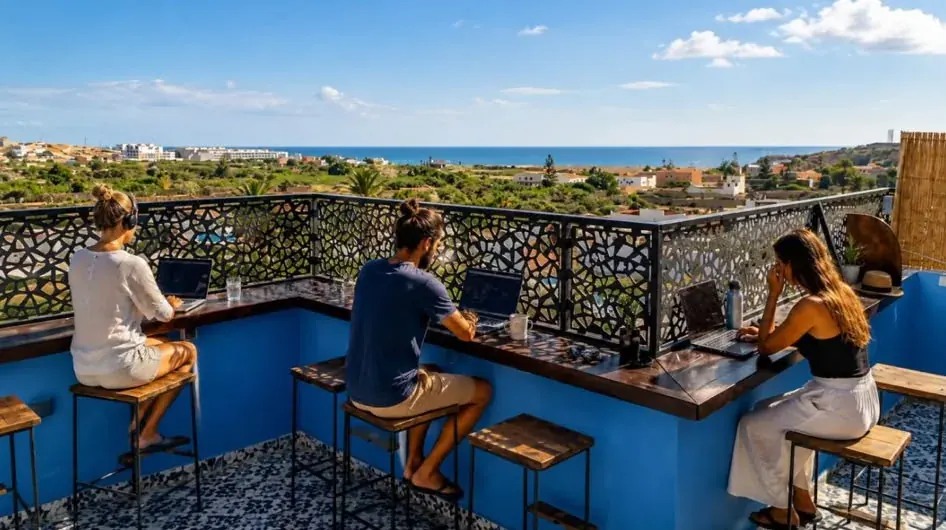 The real camp accommodation rooftop, overlooking the coast, with guests at the terrace counter